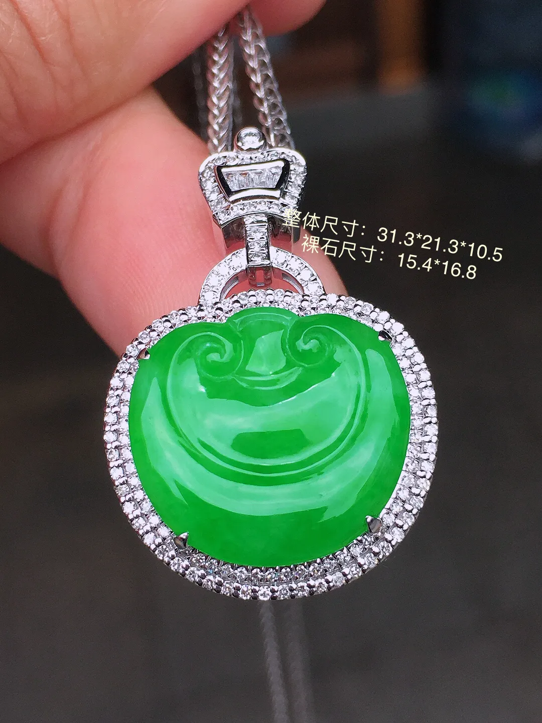 阳绿如意吊坠，色泽均匀艳丽，玉质细腻，荧光感超
强，饱满水润，气质满满。18k
金豪华镶嵌
