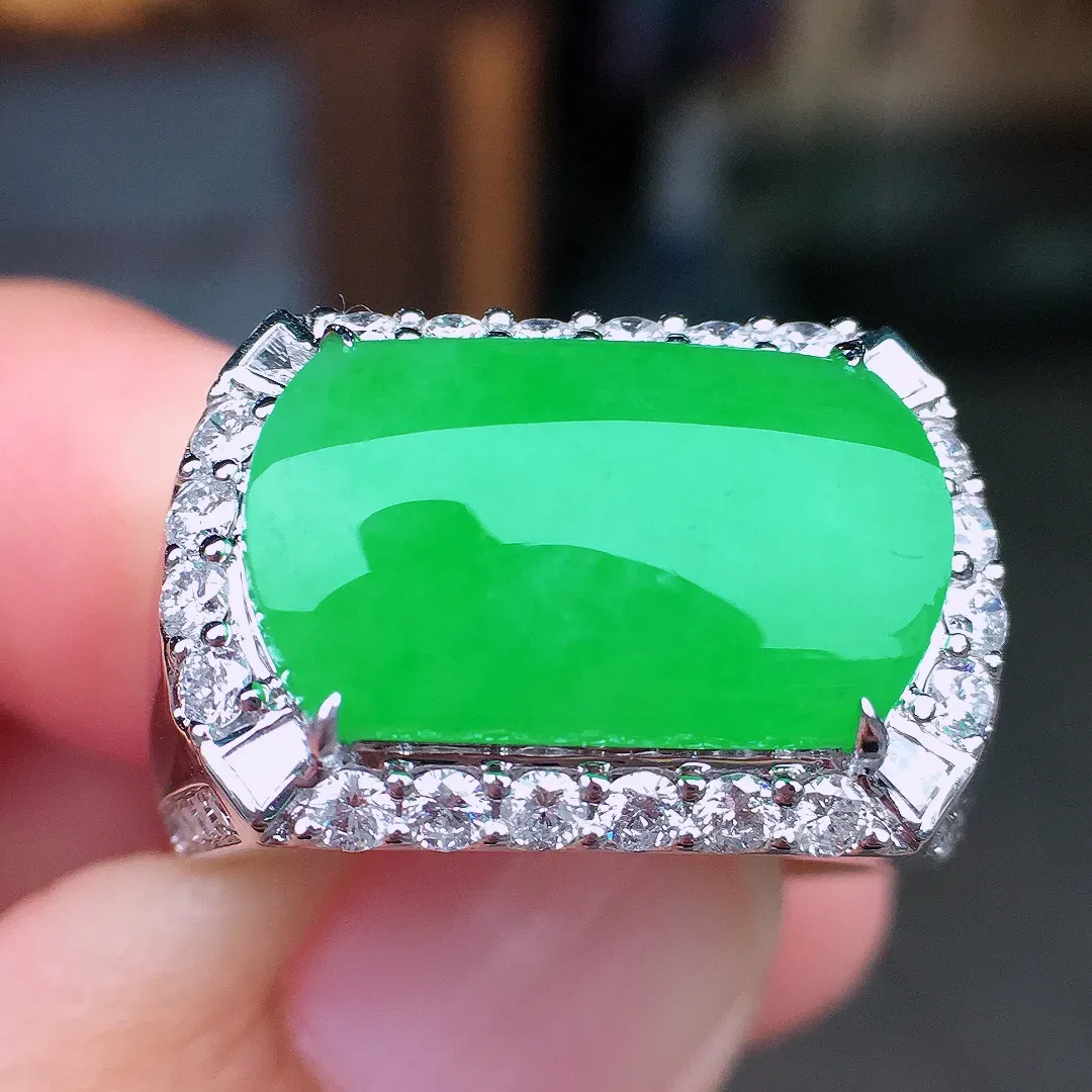 阳绿马鞍戒指，色泽均匀艳丽，玉质细腻，荧光感超
强，饱满水润，气质满满。18k
金豪华镶嵌