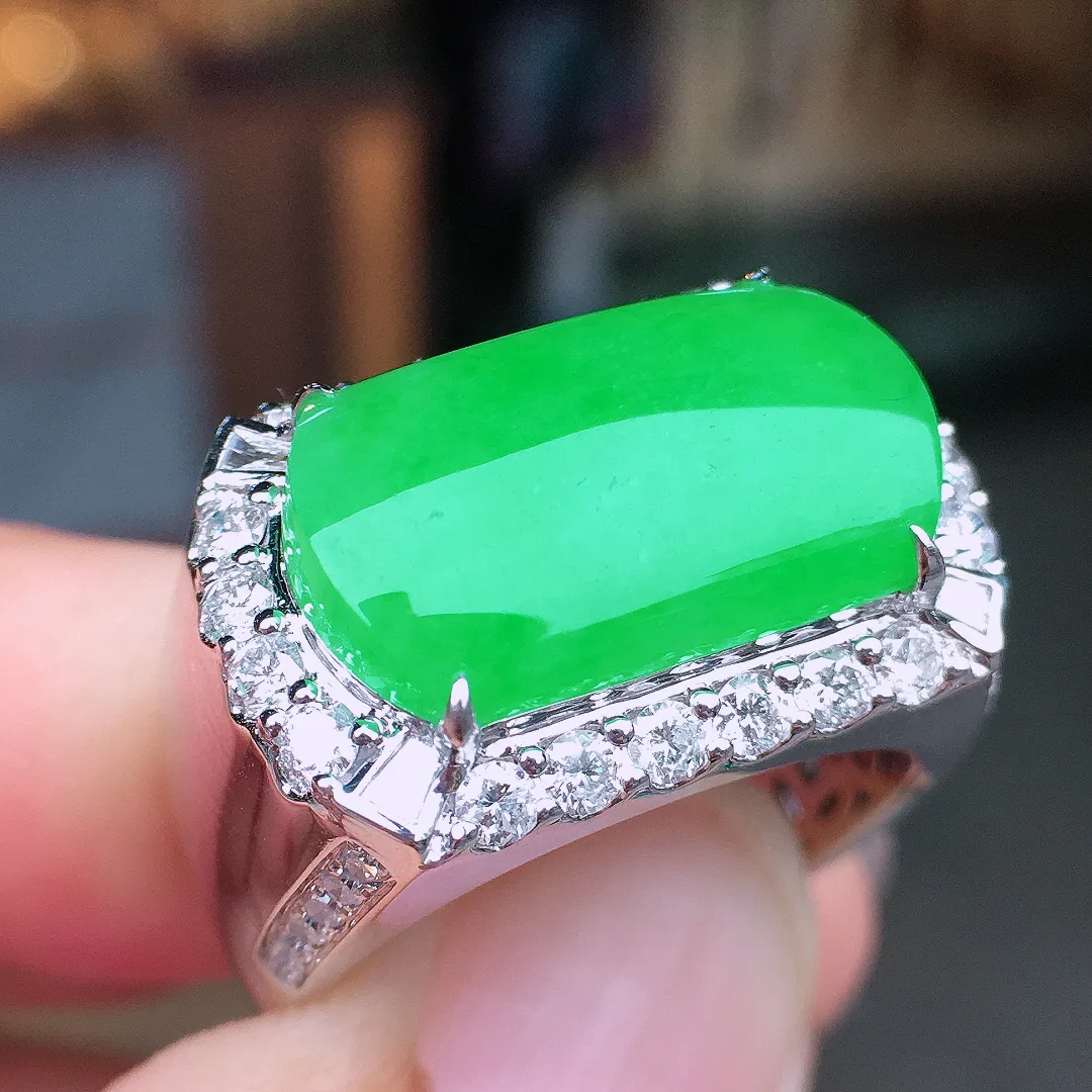 阳绿马鞍戒指，色泽均匀艳丽，玉质细腻，荧光感超
强，饱满水润，气质满满。18k
金豪华镶嵌