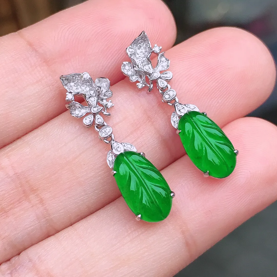 阳绿玉叶耳坠，色泽均匀艳丽，玉质细腻，荧光感超
强，饱满水润，气质满满。18k
金豪华镶嵌