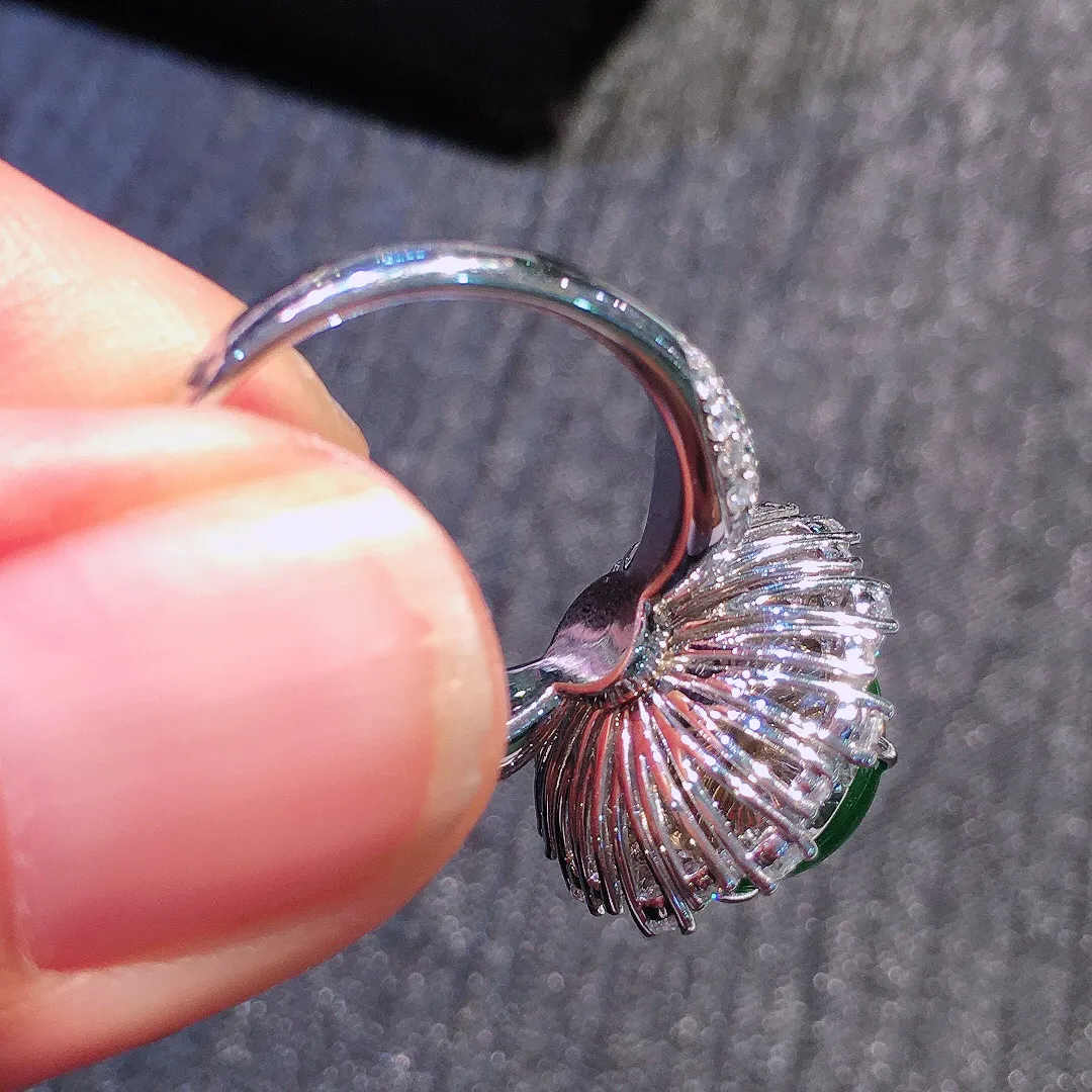 阳绿蛋面戒指，色泽均匀艳丽，玉质细腻，荧光感超
强，饱满水润，气质满满。18k
金豪华镶嵌