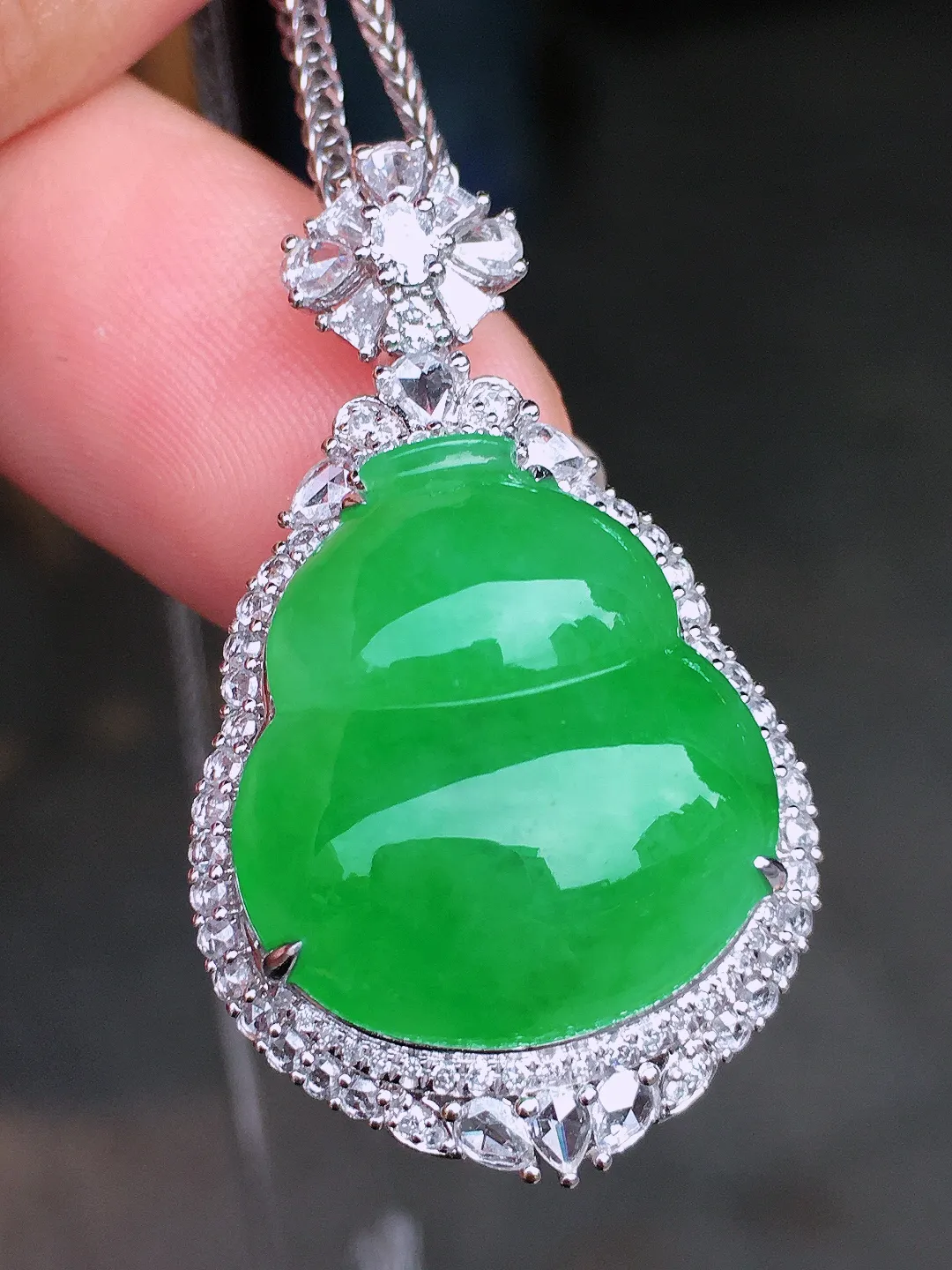 阳绿葫芦吊坠，色泽均匀艳丽，玉质细腻，荧光感超
强，饱满水润，气质满满。18k
金豪华镶嵌