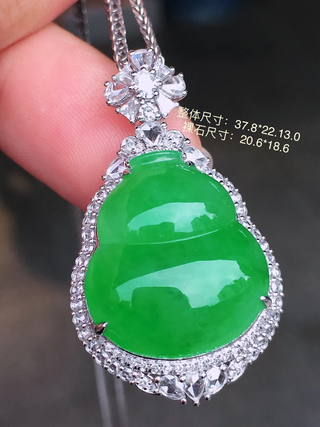 阳绿葫芦吊坠，色泽均匀艳丽，玉质细腻，荧光感超
强，饱满水润，气质满满。18k
金豪华镶嵌