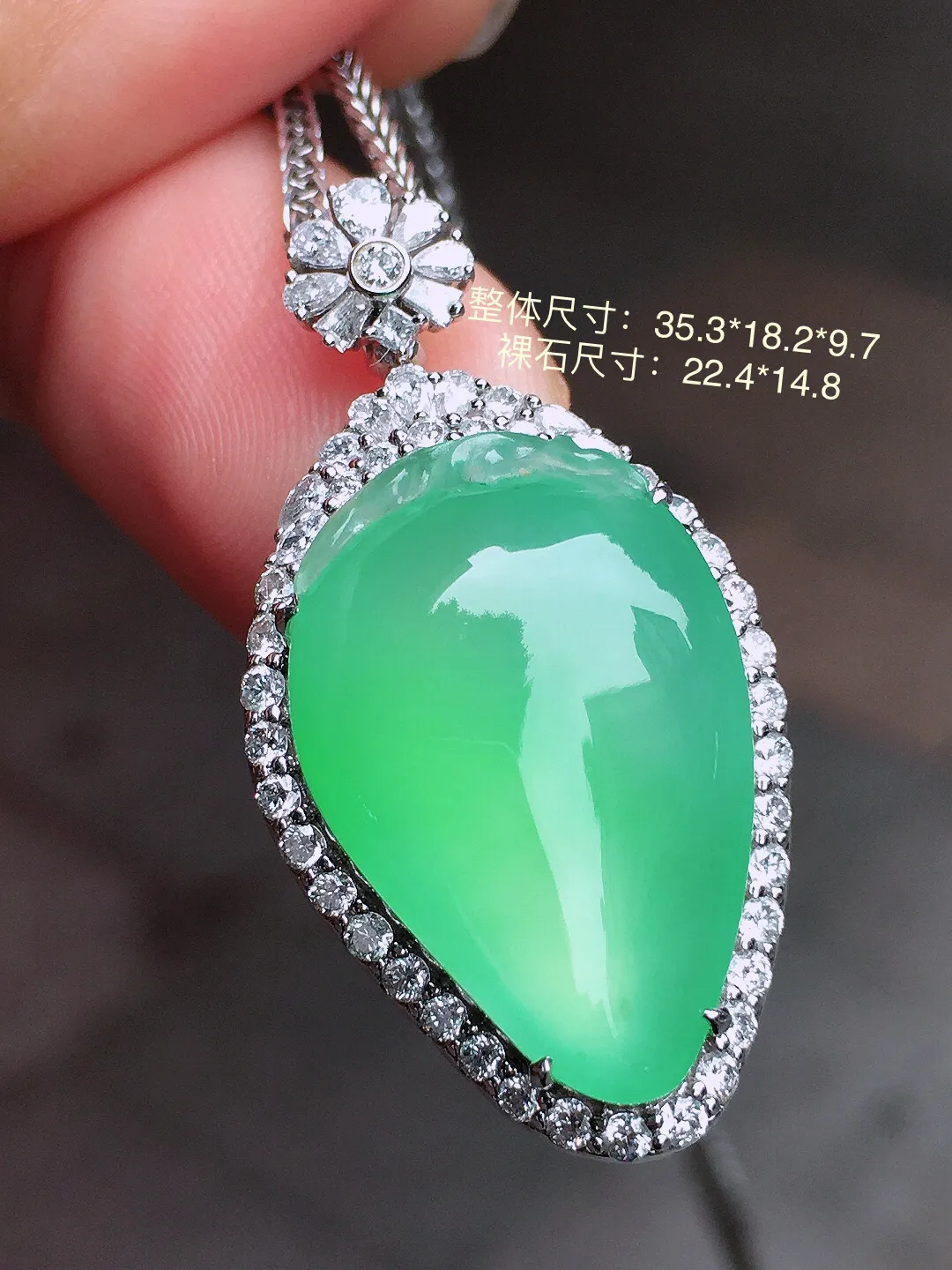 冰绿福瓜吊坠，色泽均匀艳丽，玉质细腻，荧光感超
强，饱满水润，气质满满。18k
金豪华镶嵌