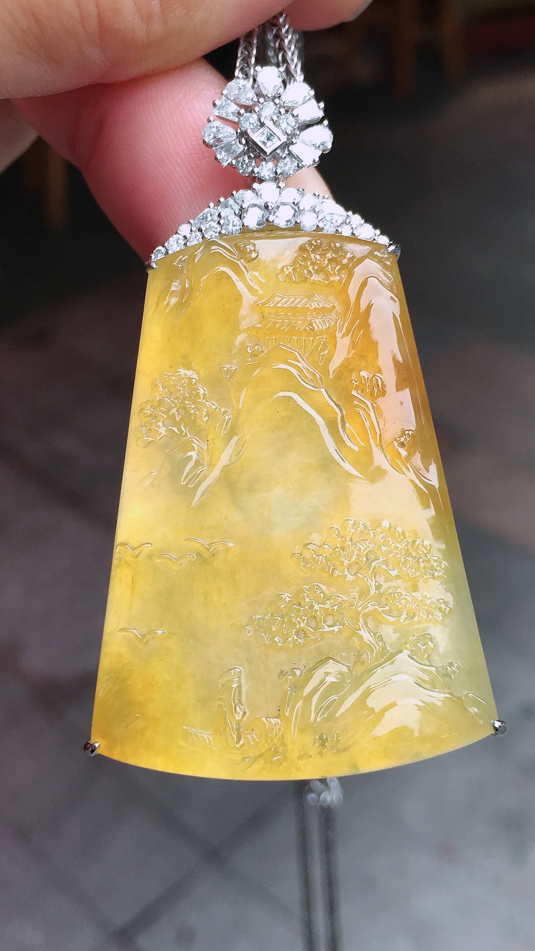 黄翡山水牌吊坠，色泽均匀艳丽，玉质细腻，荧光感超
强，饱满水润，气质满满。18k
金豪华镶嵌