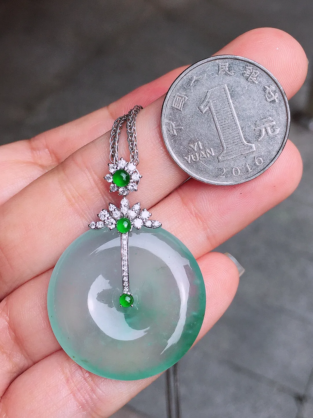 冰种平安扣吊坠，色泽均匀艳丽，玉质细腻，荧光感超
强，饱满水润，气质满满。18k
金豪华镶嵌