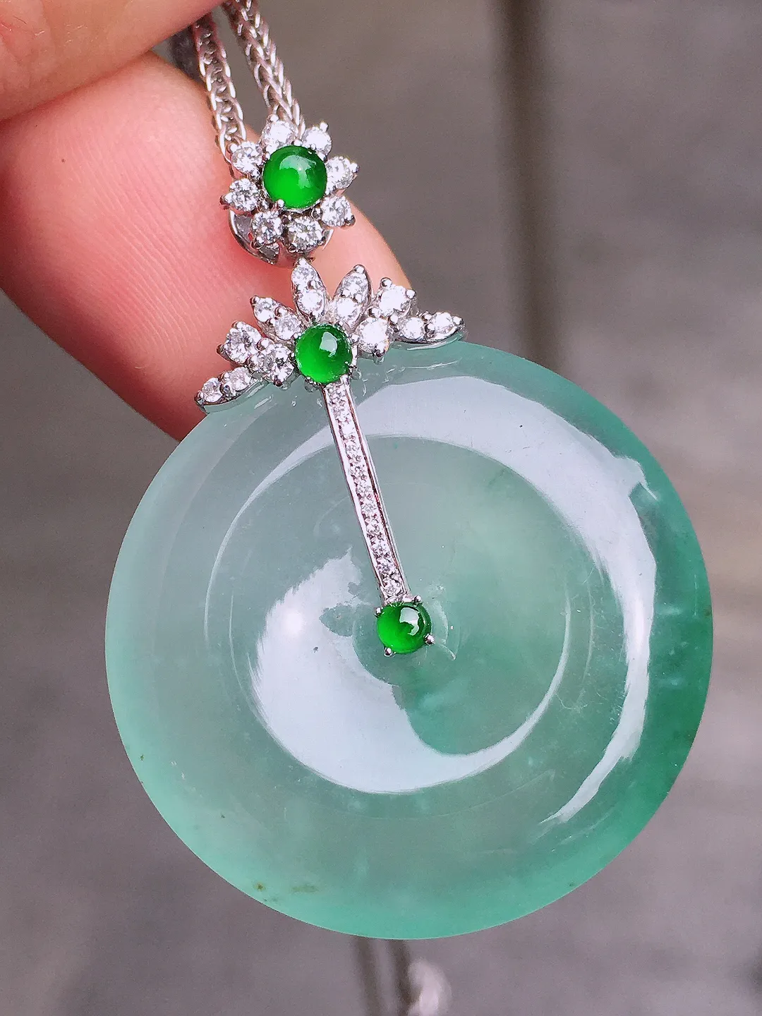 冰种平安扣吊坠，色泽均匀艳丽，玉质细腻，荧光感超
强，饱满水润，气质满满。18k
金豪华镶嵌