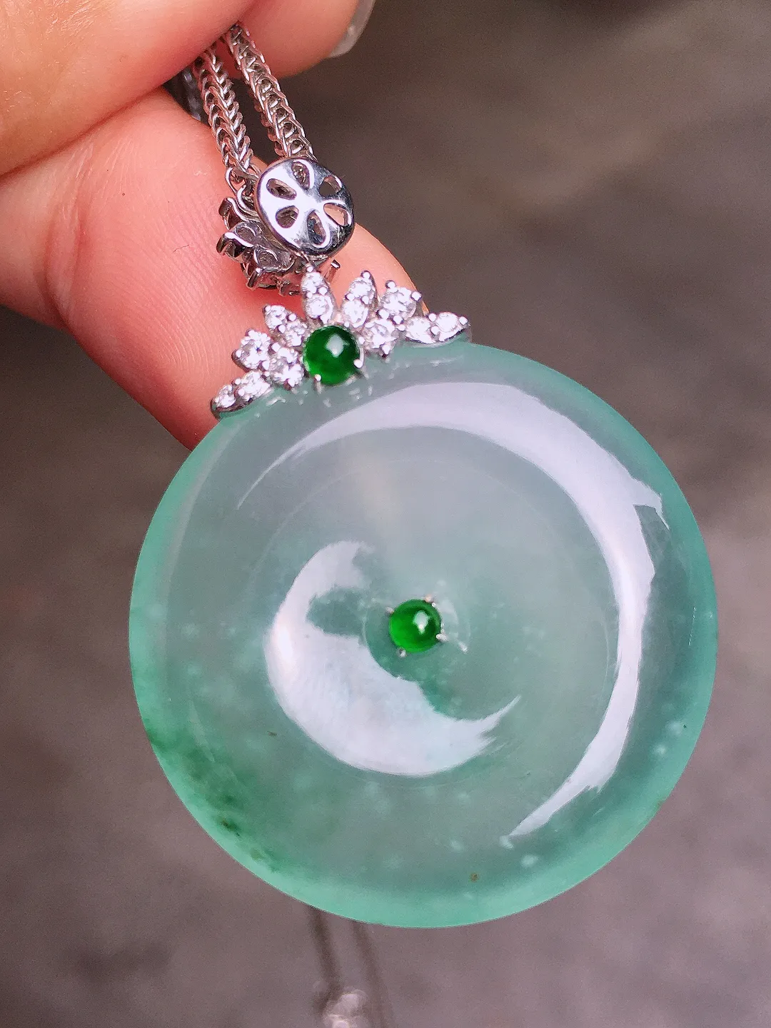 冰种平安扣吊坠，色泽均匀艳丽，玉质细腻，荧光感超
强，饱满水润，气质满满。18k
金豪华镶嵌