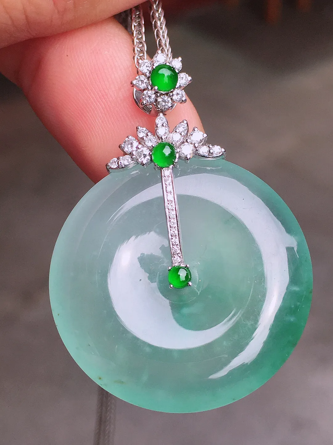 冰种平安扣吊坠，色泽均匀艳丽，玉质细腻，荧光感超
强，饱满水润，气质满满。18k
金豪华镶嵌