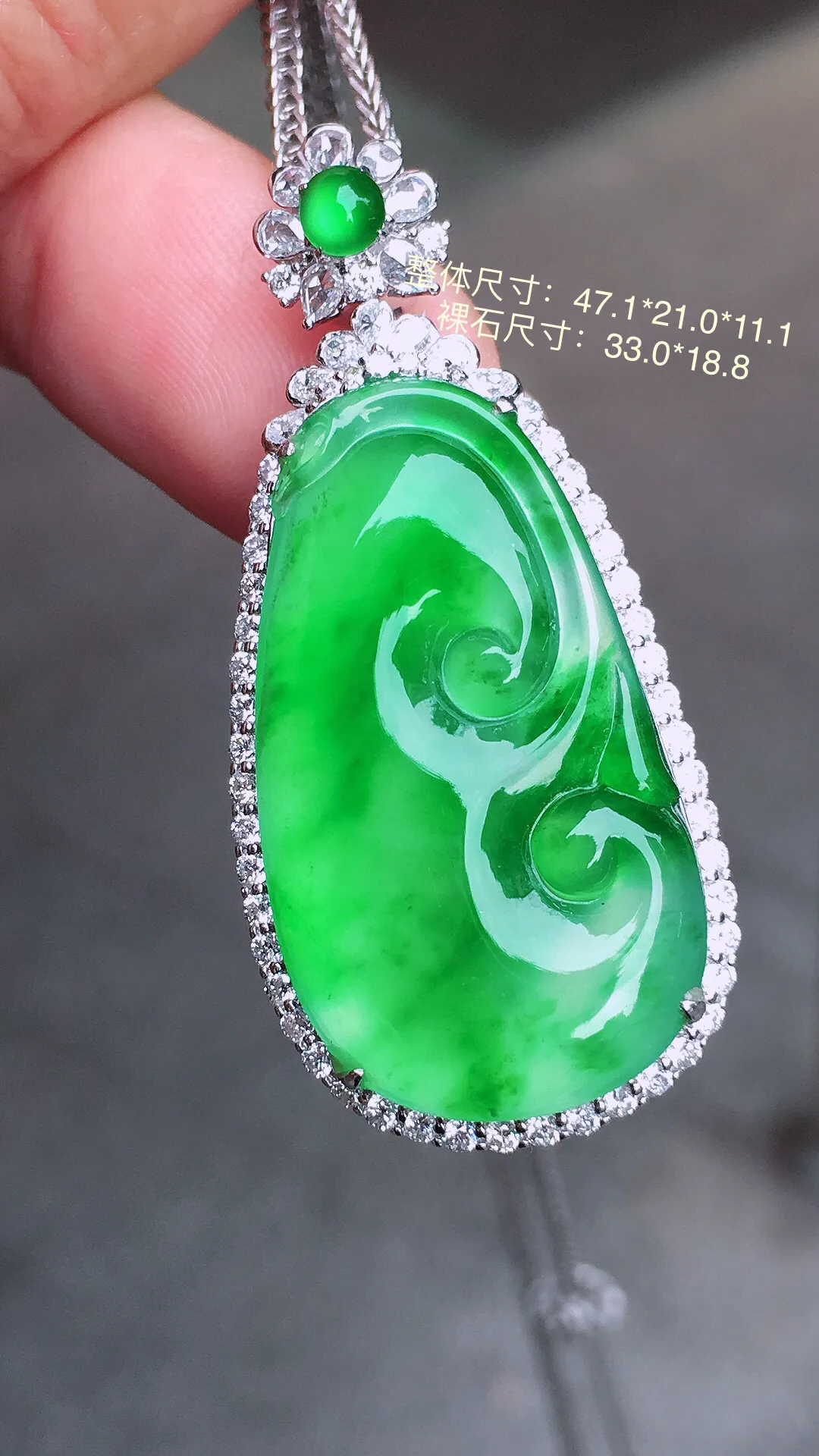 阳绿如意吊坠，色泽均匀艳丽，玉质细腻，荧光感超
强，饱满水润，气质满满。18k
金豪华镶嵌