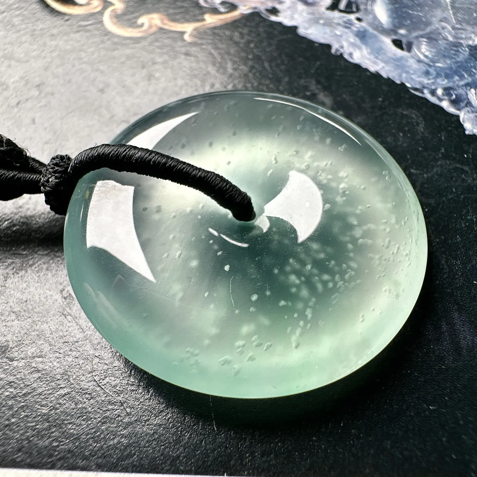 【冰种大平安扣】淡底色，近玻璃种，雪花棉老坑料，质地非常细腻，冰润十足，种老冰透，荧光闪耀。