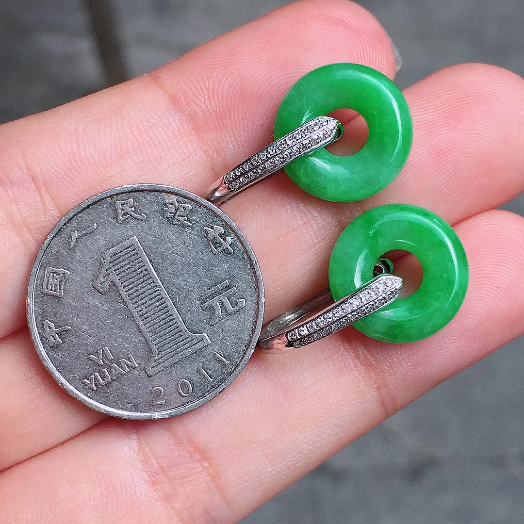 阳绿平安扣耳坠，色泽均匀艳丽，玉质细腻，荧光感超
强，饱满水润，气质满满。18k
金豪华镶嵌