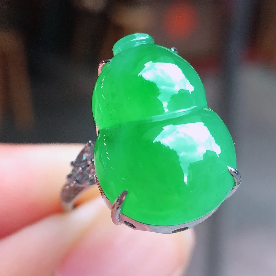 阳绿葫芦戒指，色泽均匀艳丽，玉质细腻，荧光感超
强，饱满水润，气质满满。18k
金豪华镶嵌