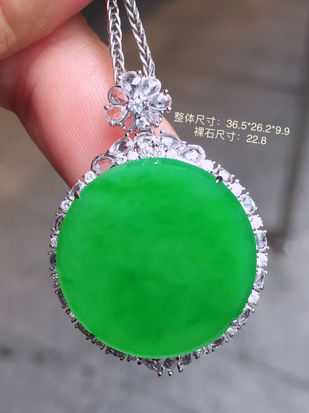 阳绿平安扣吊坠，色泽均匀艳丽，玉质细腻，荧光感超
强，饱满水润，气质满满。18k
金豪华镶嵌