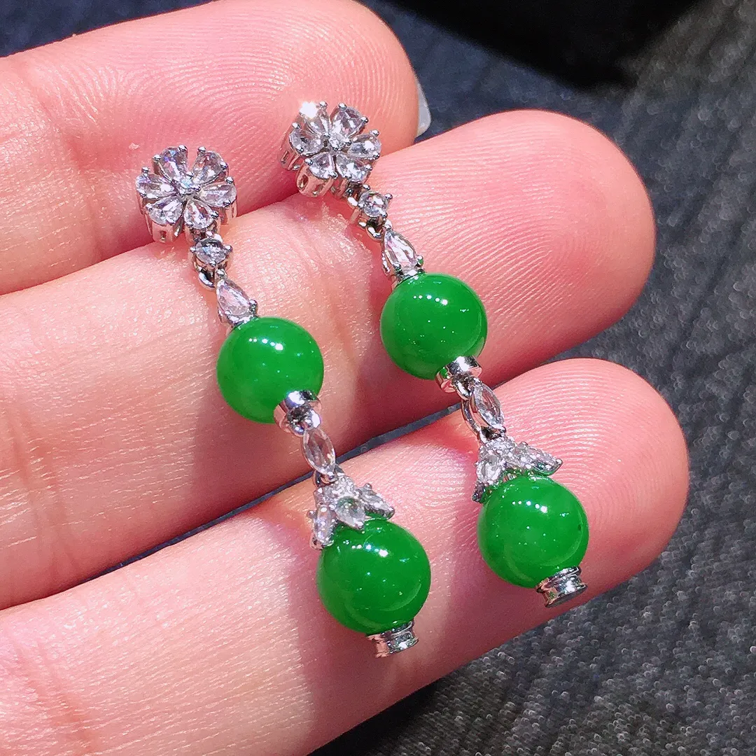 阳绿珠子耳坠，色泽均匀艳丽，玉质细腻，荧光感超
强，饱满圆润，气质满满。18k
金豪华镶嵌