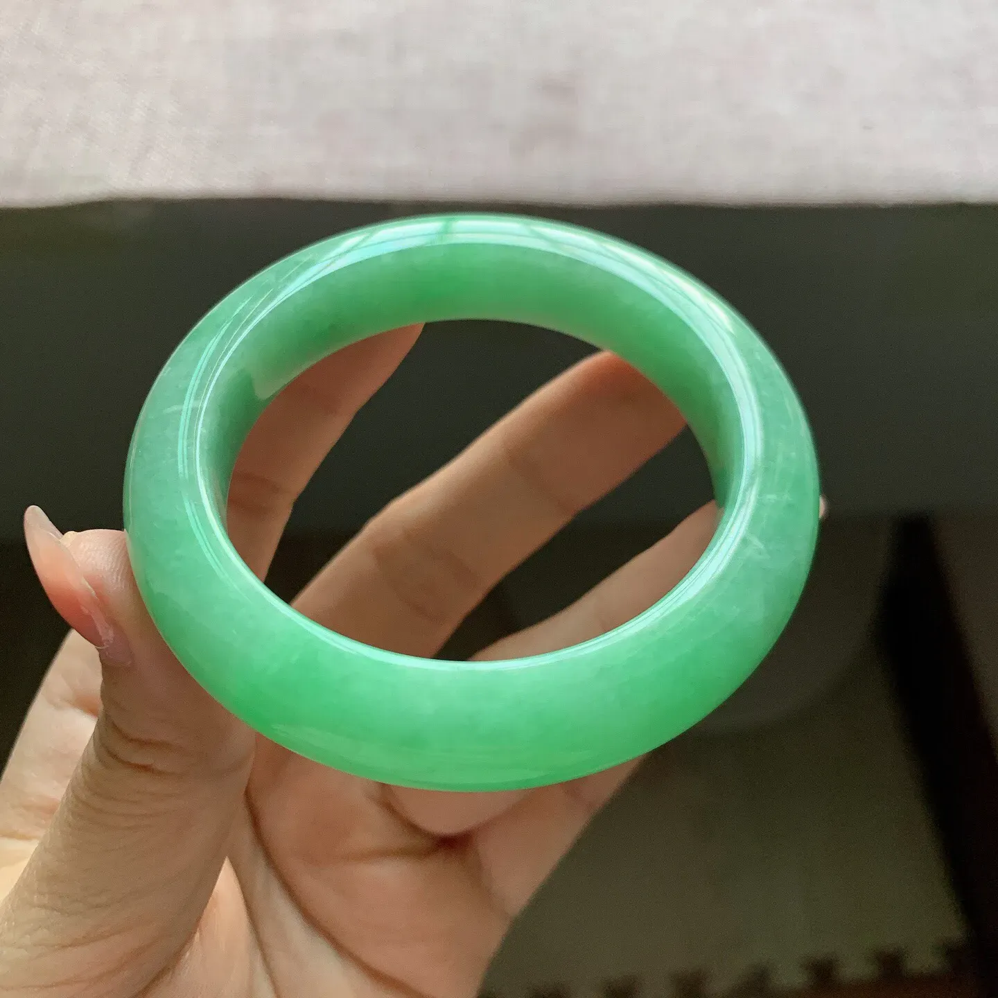 53-54圈口。自然光实拍，老坑冰润满绿正圈翡翠手镯，尺寸:54-11.6-9.7mm，重量65.18g，无纹裂，
