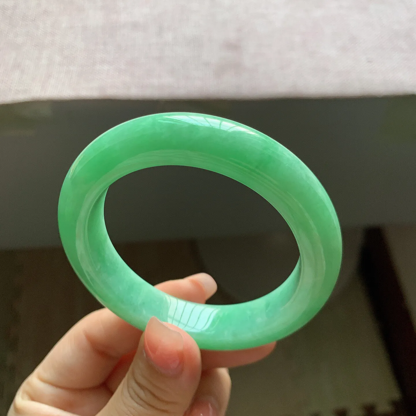 53-54圈口。自然光实拍，老坑冰润满绿正圈翡翠手镯，尺寸:54-11.6-9.7mm，重量65.18g，无纹裂，