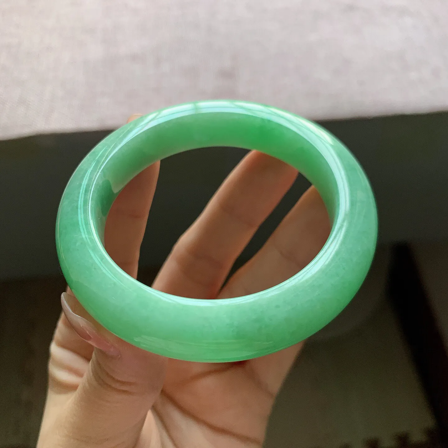 53-54圈口。自然光实拍，老坑冰润满绿正圈翡翠手镯，尺寸:54-11.6-9.7mm，重量65.18g，无纹裂，