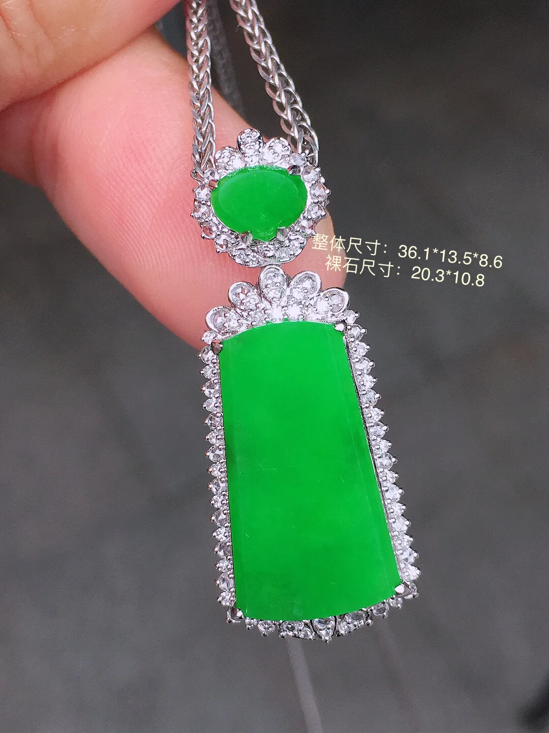 阳绿无事牌吊坠，色泽均匀艳丽，玉质细腻，荧光感超
强，饱满圆润，气质满满。18k
金豪华镶嵌