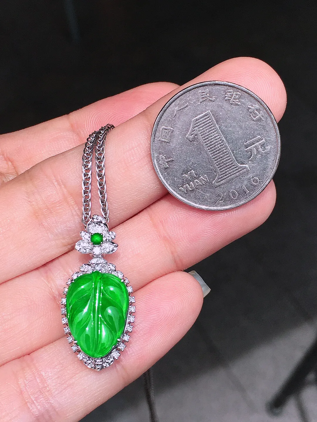 阳绿玉叶吊坠，色泽均匀艳丽，玉质细腻，荧光感超
强，饱满圆润，气质满满。18k
金豪华镶嵌