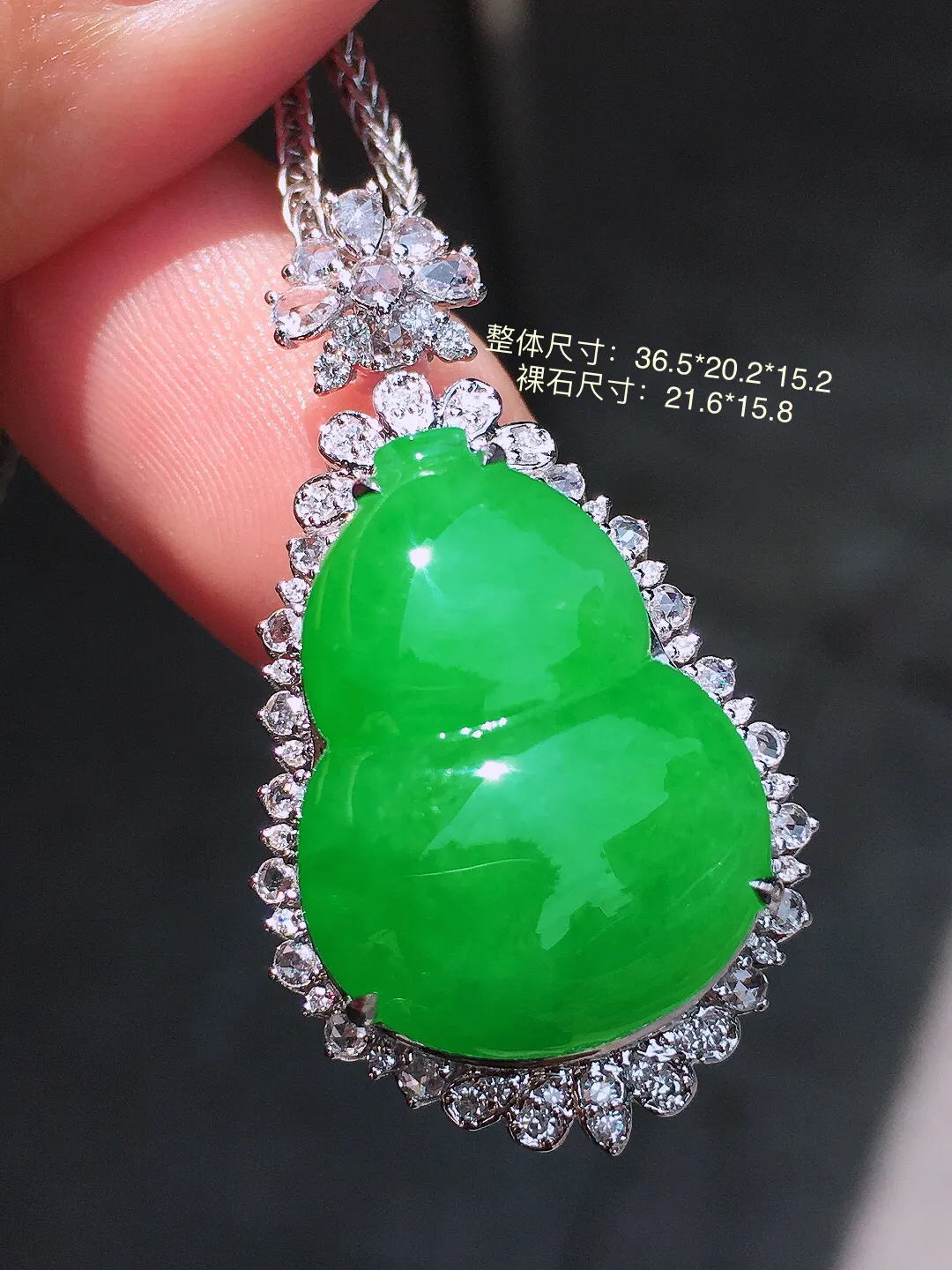 阳绿葫芦吊坠，色泽均匀艳丽，玉质细腻，荧光感超
强，饱满圆润，气质满满。18k
金豪华镶嵌