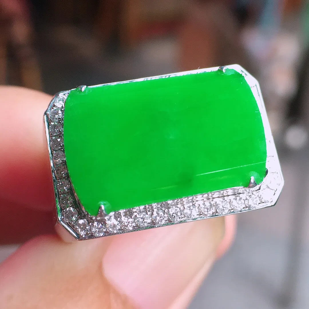 阳绿马鞍戒指，色泽均匀艳丽，玉质细腻，荧光感超
强，饱满圆润，气质满满。18k
金豪华镶嵌