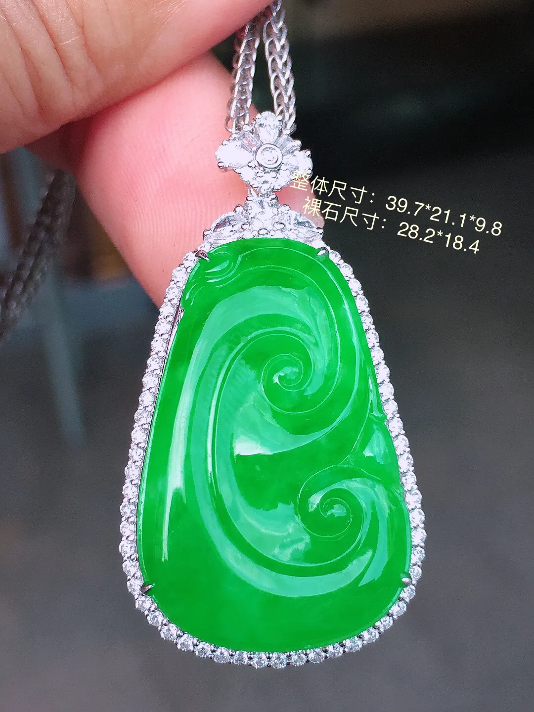 阳绿如意吊坠，色泽均匀艳丽，玉质细腻，荧光感超
强，饱满圆润，气质满满。18k
金豪华镶嵌