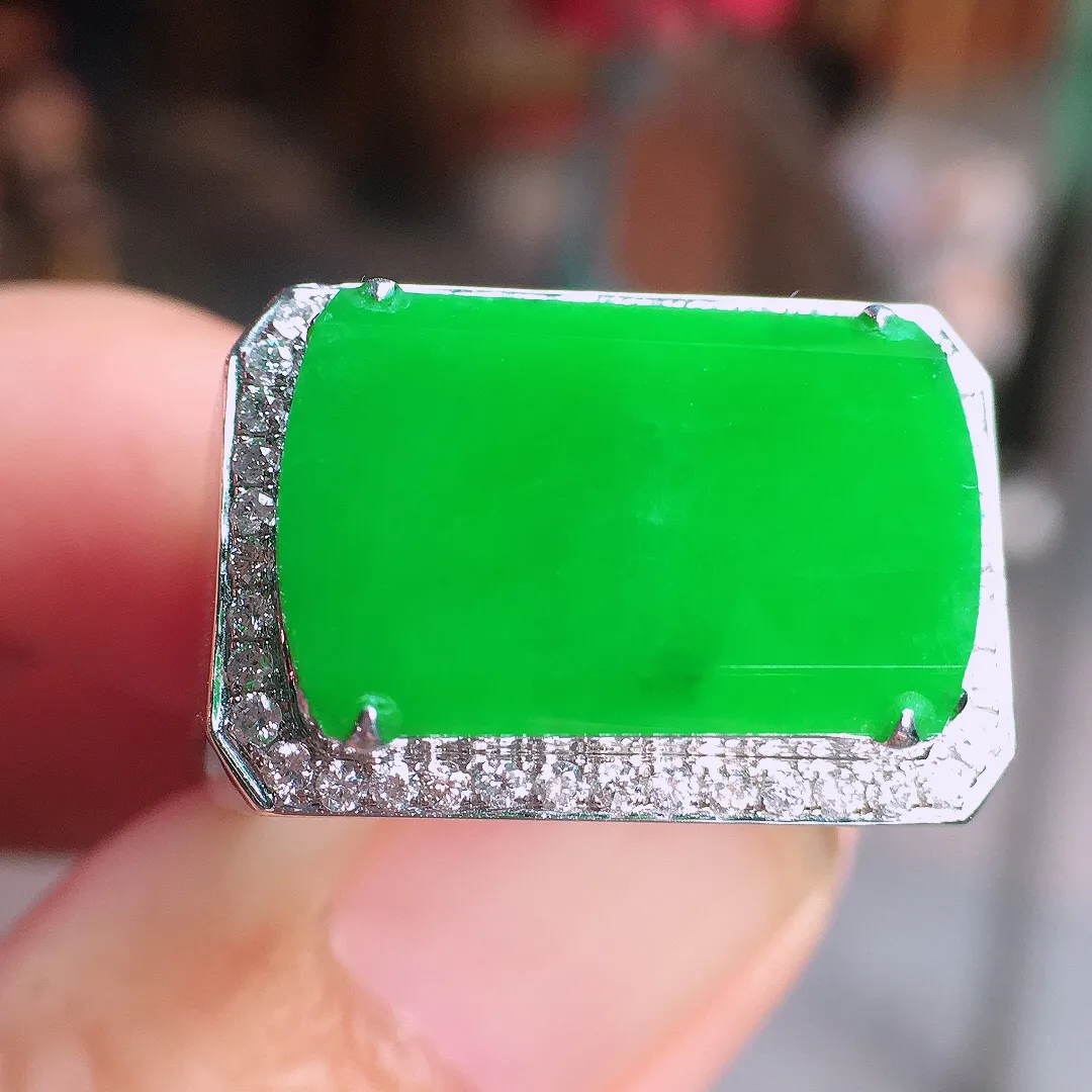 阳绿马鞍戒指，色泽均匀艳丽，玉质细腻，荧光感超
强，饱满圆润，气质满满。18k
金豪华镶嵌
