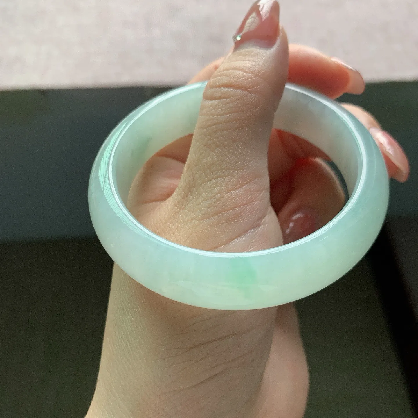 56-57圈口。自然光实拍，老坑冰润浅绿正圈翡翠手镯，尺寸:56.9-14.7-7.9mm，重量64.30g，无纹裂
