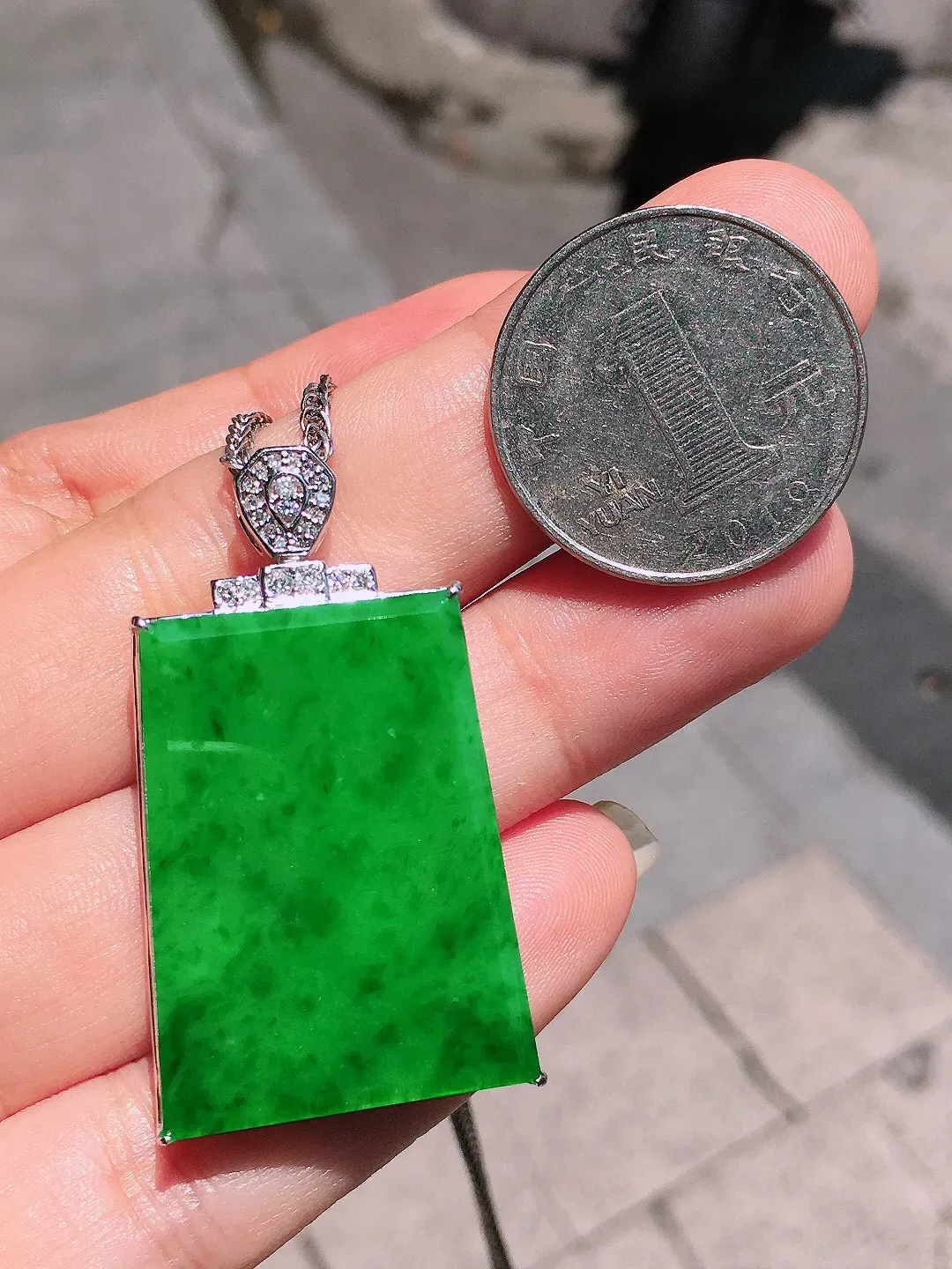 阳绿无事牌吊坠，色泽均匀艳丽，玉质细腻，荧光感超
强，饱满圆润，气质满满。18k
金豪华镶嵌