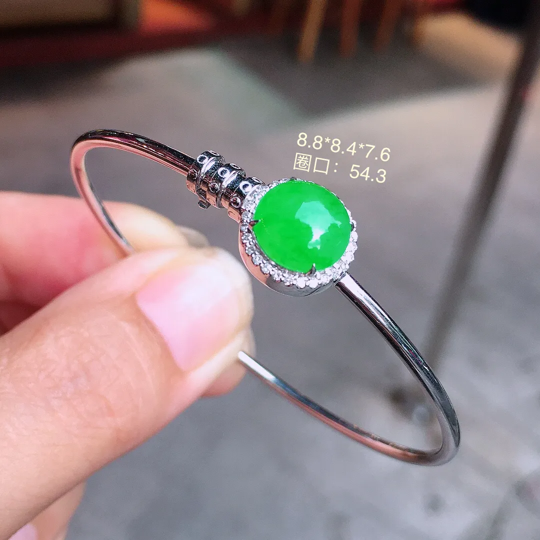 阳绿蛋面手镯，色泽均匀艳丽，玉质细腻，荧光感超
强，饱满圆润，气质满满。18k
金豪华镶嵌