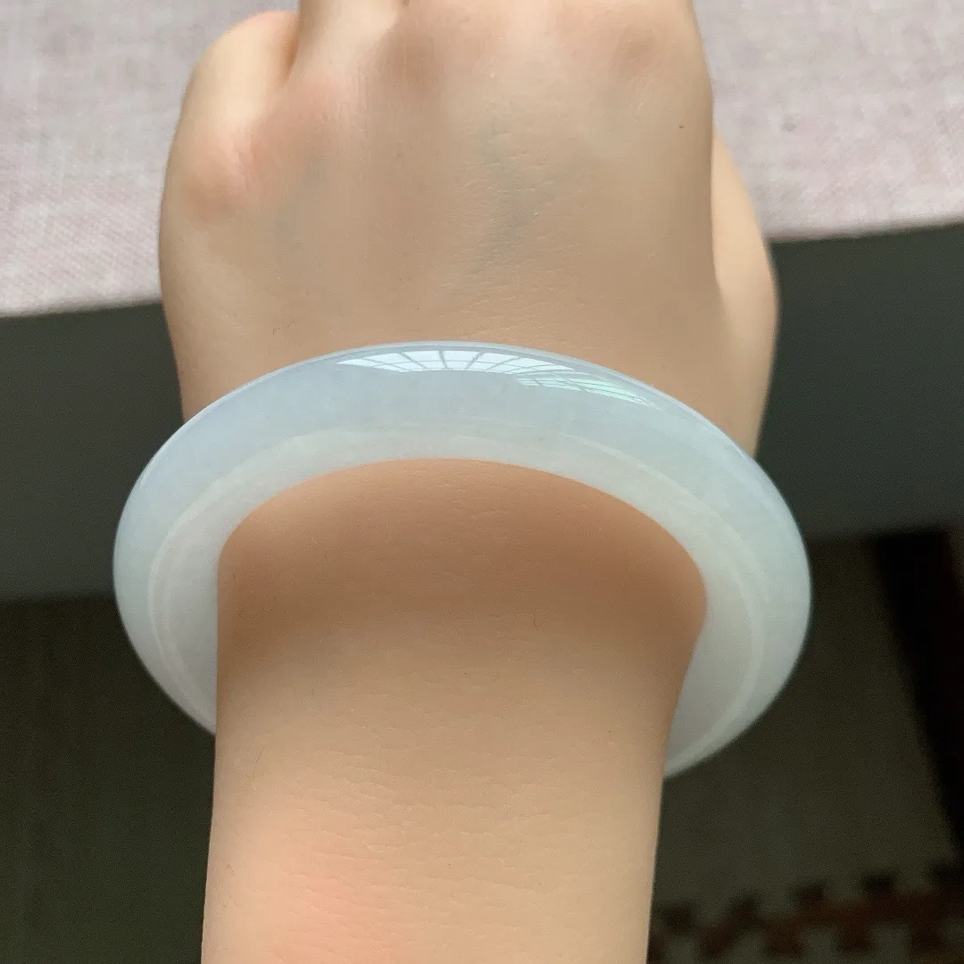 56-55圈口。自然光实拍，老坑冰胶白月光胖圆条翡翠手镯，尺寸:55.6-10.6mm，重量66.07g