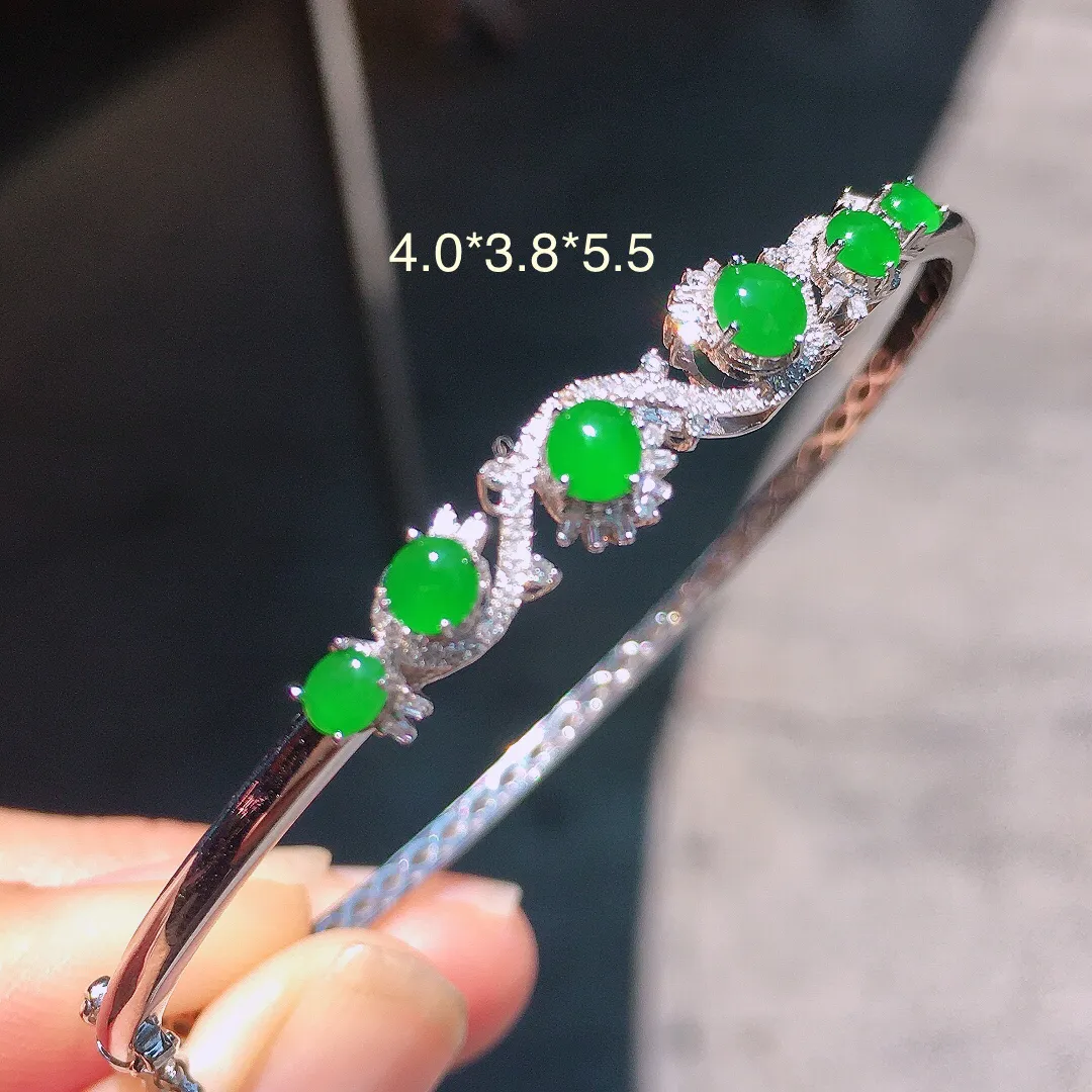 阳绿蛋面手镯，色泽均匀艳丽，玉质细腻，荧光感超
强，饱满圆润，气质满满。18k
金豪华镶嵌