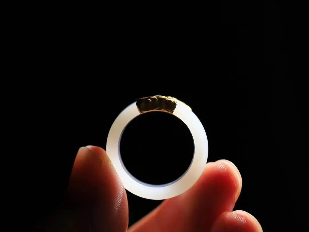 【金镶玉.戒指】

精品和田玉白玉AU750金戒指 玉质细腻温润 油性十足 ，不论时光如何流转变化，这枚戒指始终闪耀着最初的光芒。精工镶嵌18K金 （保真金 可检测贵金属AU750金） 重5.7克 尺寸18-12.8-3.7mm 78602958A