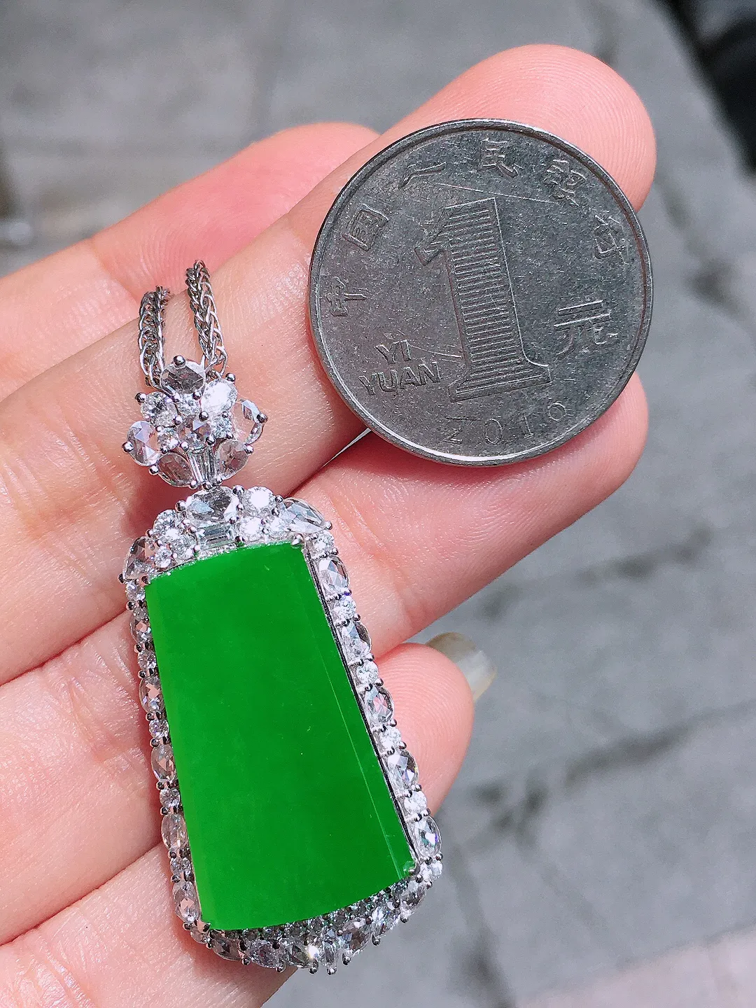 阳绿无事牌吊坠，色泽均匀艳丽，玉质细腻，荧光感超
强，饱满圆润，气质满满。18k
金豪华镶嵌