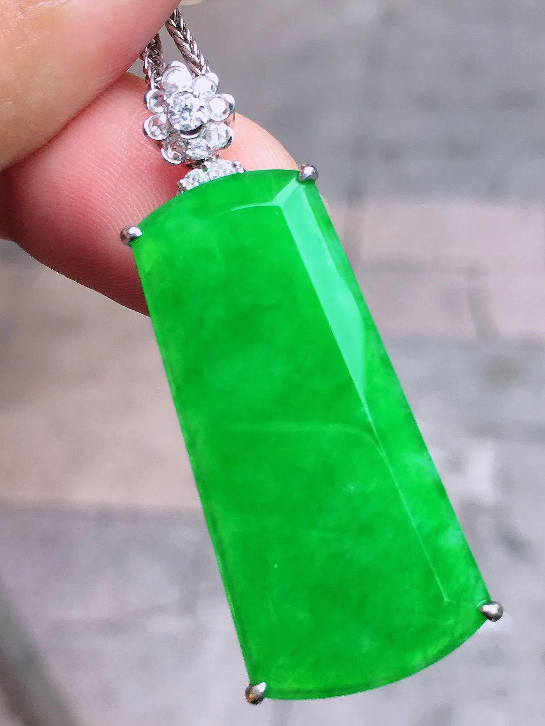阳绿无事牌吊坠，色泽均匀艳丽，玉质细腻，荧光感超
强，饱满圆润，气质满满。18k
金豪华镶嵌