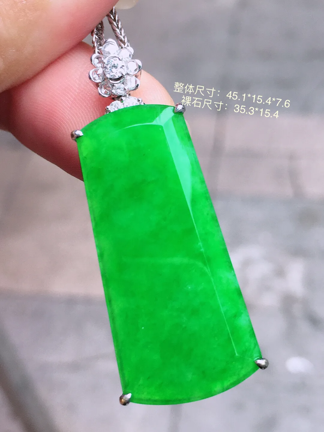 阳绿无事牌吊坠，色泽均匀艳丽，玉质细腻，荧光感超
强，饱满圆润，气质满满。18k
金豪华镶嵌
