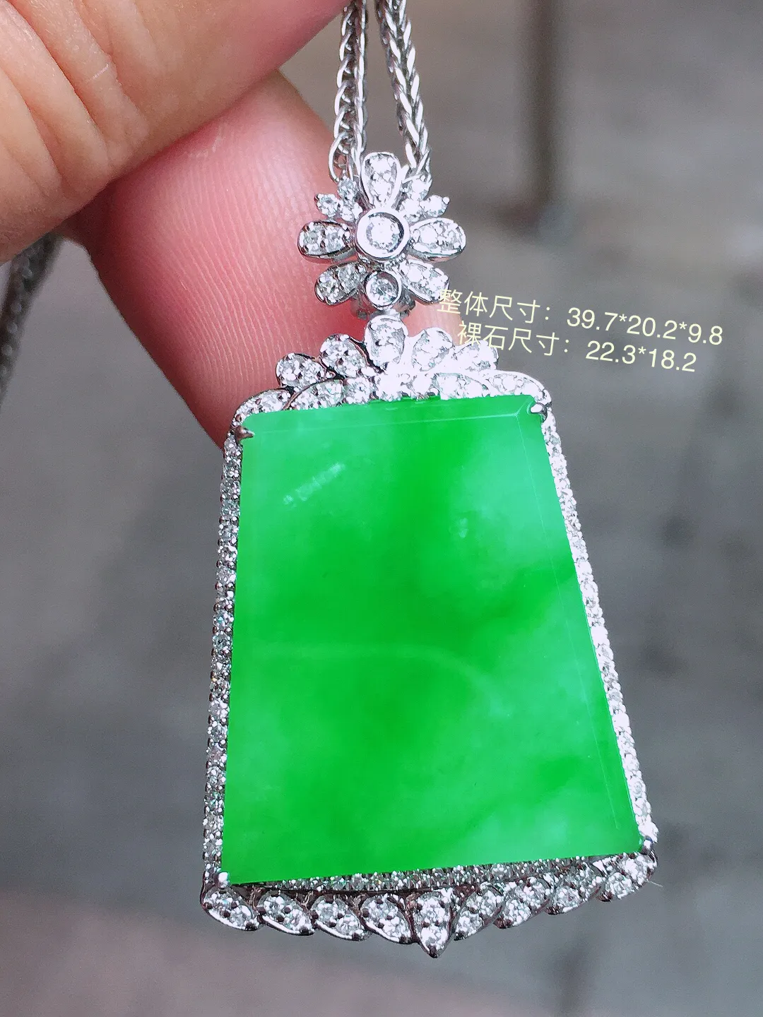 阳绿无事牌吊坠，色泽均匀艳丽，玉质细腻，荧光感超
强，饱满圆润，气质满满。18k
金豪华镶嵌