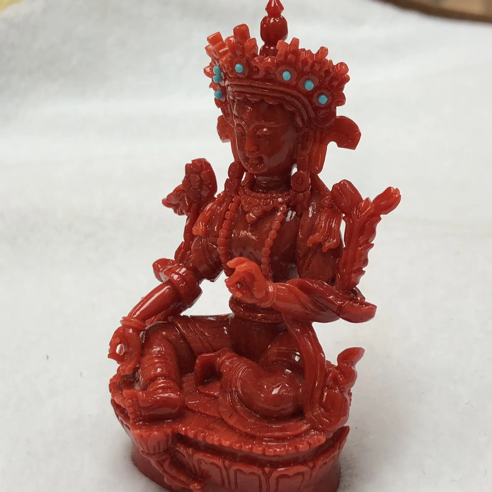 【天然红珊瑚拼接绿镀母小佛摆件】意大利产地，沙丁珊瑚料，深红颜色，釆用台湾拼接手工工艺，精雕细镂，底部有开孔可藏经文，手工工序复杂，高约85mm，宽约51mm，厚39.8mm，重量75.5克。天然美松点缀！可手持红珊瑚沙丁大枝拼接绿镀母。收藏供奉价值高！