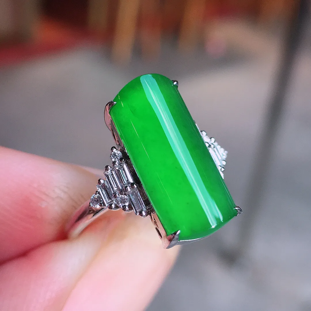 阳绿马鞍戒指，色泽均匀艳丽，玉质细腻，荧光感超
强，饱满圆润，气质满满。18k
金豪华镶嵌