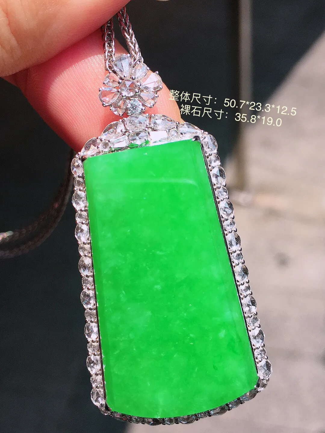 阳绿无事牌吊坠，色泽均匀艳丽，玉质细腻，荧光感超
强，饱满圆润，气质满满。18k
金豪华镶嵌