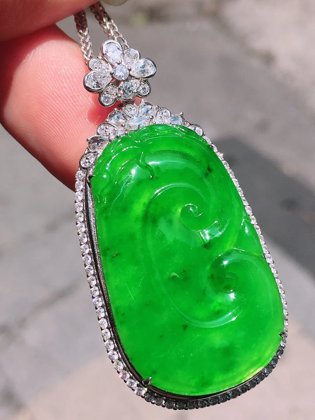 阳绿如意吊坠，色泽均匀艳丽，玉质细腻，荧光感超
强，饱满圆润，气质满满。18k
金豪华镶嵌
