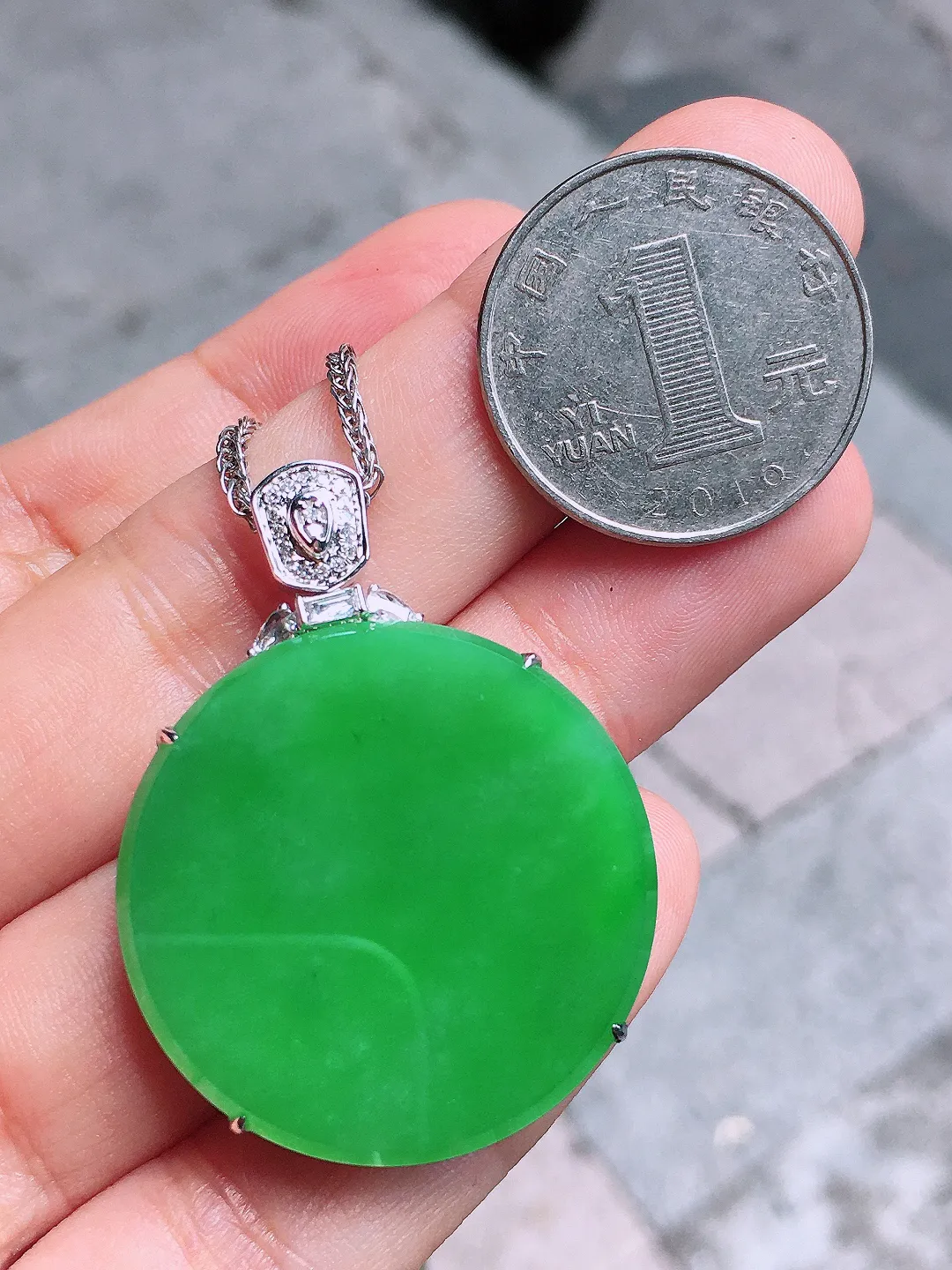 阳绿平安扣吊坠，色泽均匀艳丽，玉质细腻，荧光感超
强，饱满圆润，气质满满。18k
金豪华镶嵌