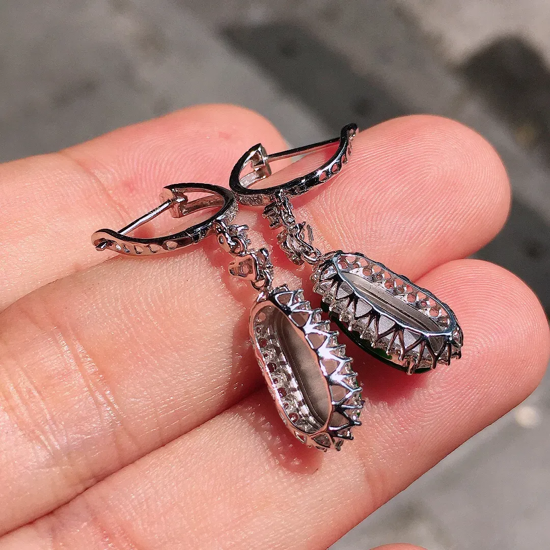 阳绿福豆耳坠，色泽均匀艳丽，玉质细腻，荧光感超
强，饱满圆润，气质满满。18k
金豪华镶嵌
