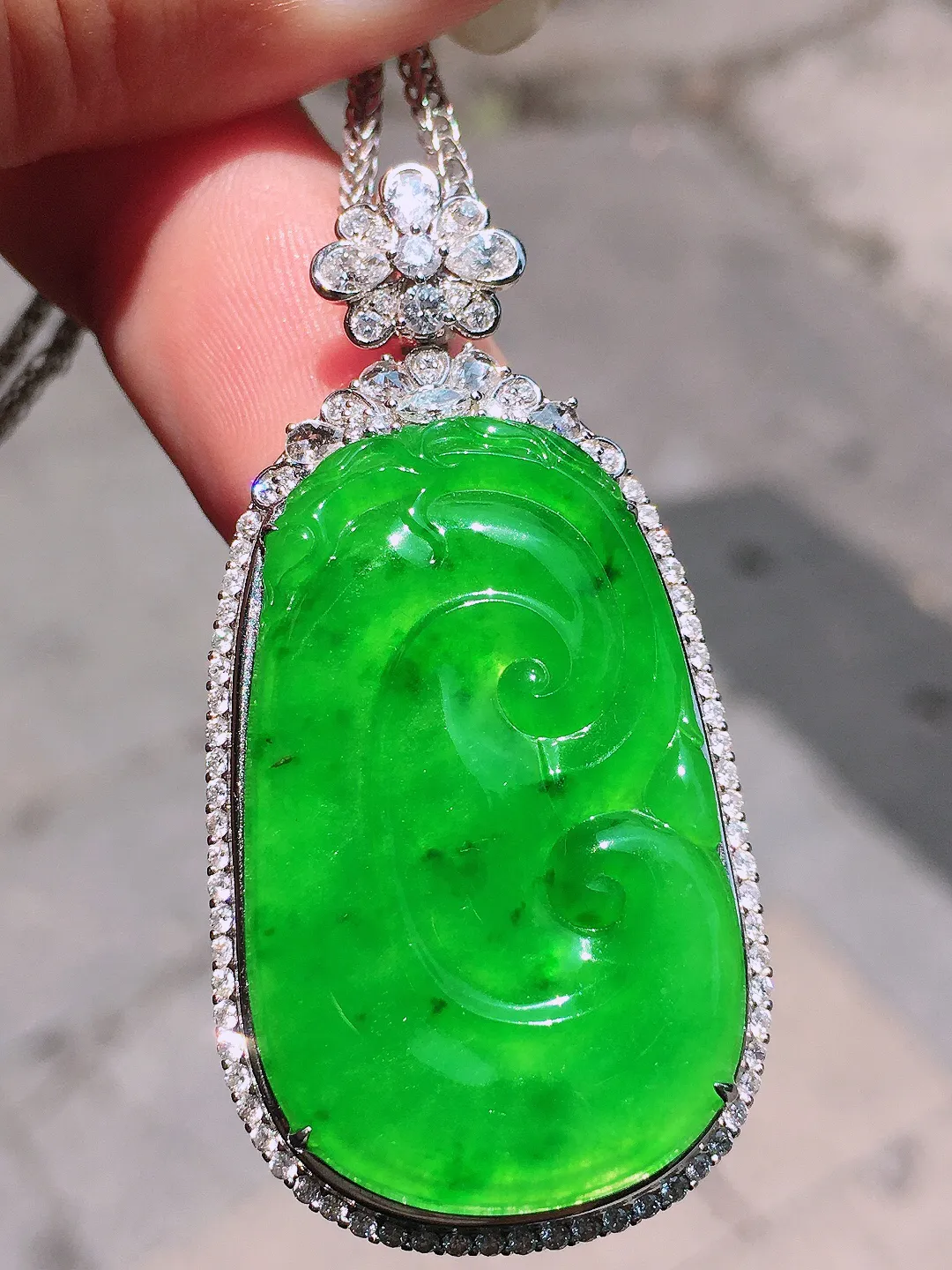 阳绿如意吊坠，色泽均匀艳丽，玉质细腻，荧光感超
强，饱满圆润，气质满满。18k
金豪华镶嵌