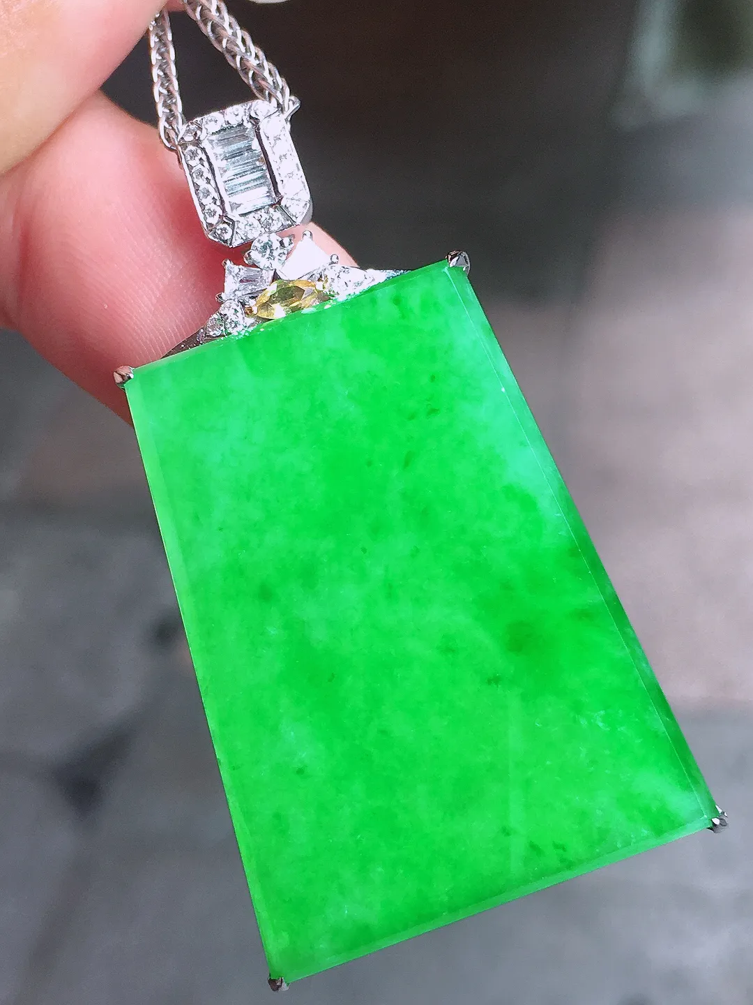 阳绿无事牌吊坠，色泽均匀艳丽，玉质细腻，荧光感超
强，饱满圆润，气质满满。18k
金豪华镶嵌
