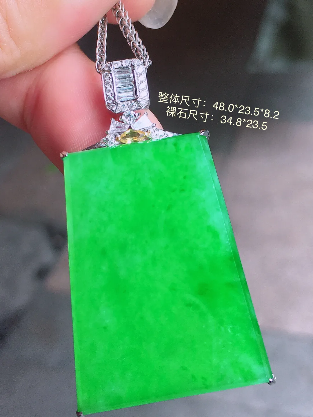 阳绿无事牌吊坠，色泽均匀艳丽，玉质细腻，荧光感超
强，饱满圆润，气质满满。18k
金豪华镶嵌