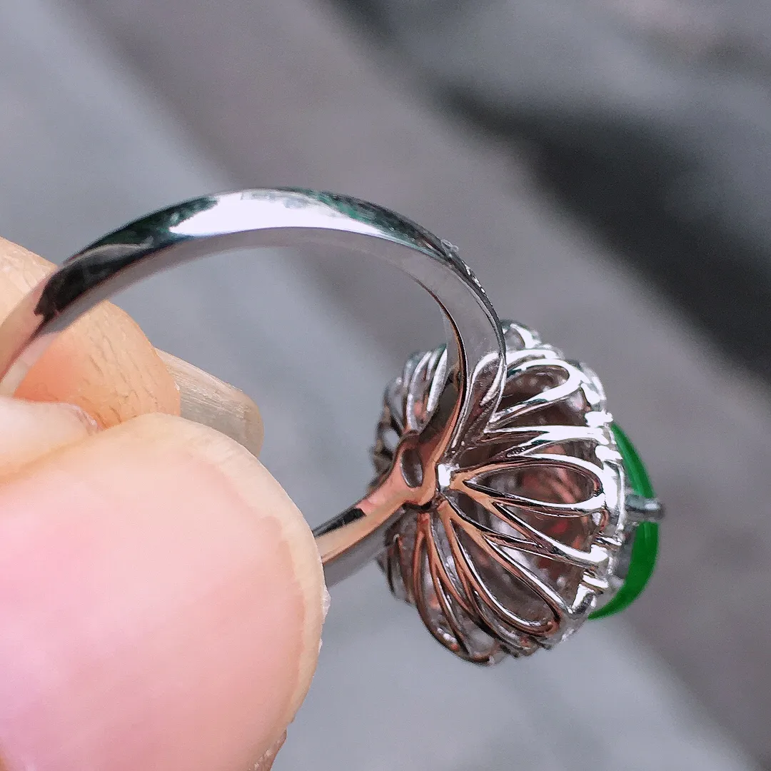 阳绿蛋面戒指，色泽均匀艳丽，玉质细腻，荧光感超
强，饱满圆润，气质满满。18k
金豪华镶嵌