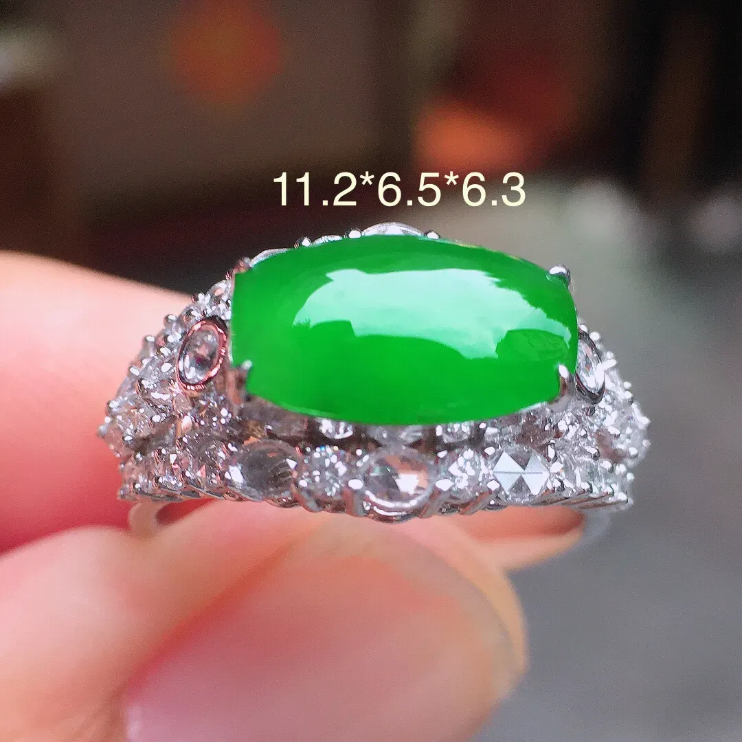 阳绿马鞍戒指，色泽均匀艳丽，玉质细腻，荧光感超
强，饱满圆润，气质满满。18k
金豪华镶嵌