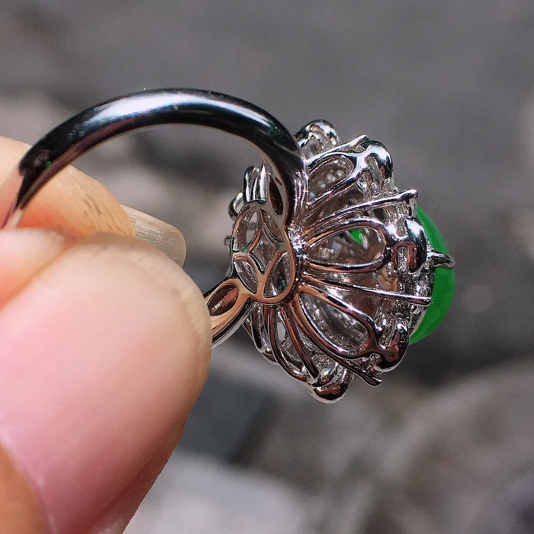 阳绿蛋面戒指，色泽均匀艳丽，玉质细腻，荧光感超
强，饱满圆润，气质满满。18k
金豪华镶嵌